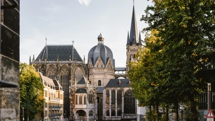 Aachener Dom vom Katschhof Blick über den Katschhof auf den Dom, rechts und links stehen grüne Bäume.