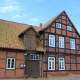 Fachwerkgebäude aus rotem Backstein mit Sprossenfenstern, ansprechende alte Wassermühle in ländlicher Umgebung.