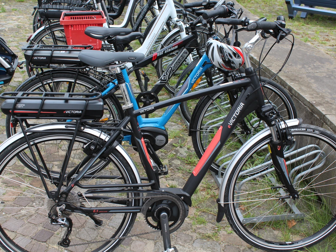 Radfahren Mehrere Fahrräder stehen geordnet auf einem gepflasterten Parkplatz, bereit zur Nutzung.