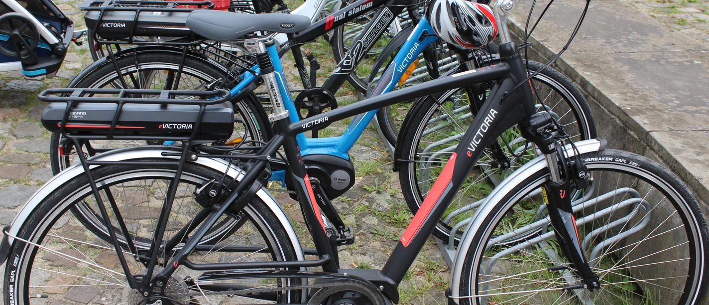Radfahren Mehrere Fahrräder stehen geordnet auf einem gepflasterten Parkplatz, bereit zur Nutzung.