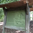 Alte Schanze Oyler Berg Infotafel im Wald mit historischem Plan und Text zur "Alten Schanze" auf dem Oyler Berg im Hintergrund.