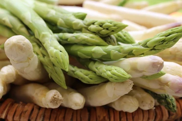 Spargelstangen Frischer grüner und weißer Spargel in Nahaufnahme, liegend auf einem hölzernen Untergrund.