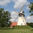 Windmühle Heimsen Windmühle Heimsen mit rotem Dach und großen Flügeln umgeben von Bäumen unter blauem Himmel.