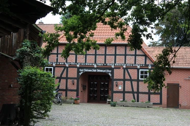 Hofmuseum Stakmann Fachwerkhaus des Hofmuseums Stakmann mit roten Ziegeln, umgeben von Bäumen, Fahrräder lehnen an der Wand.