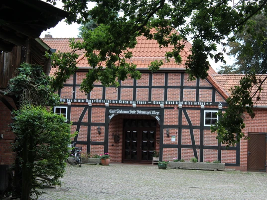 Hofmuseum Stakmann Fachwerkhaus des Hofmuseums Stakmann mit roten Ziegeln, umgeben von Bäumen, Fahrräder lehnen an der Wand.