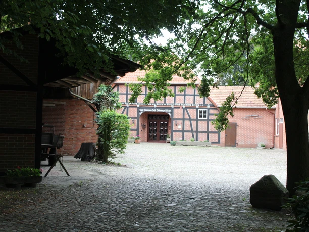 Hofmuseum Stakmann Eingang des historischen Hofmuseums Stakmann mit Fachwerkfassade und von Bäumen gesäumtem Hof.