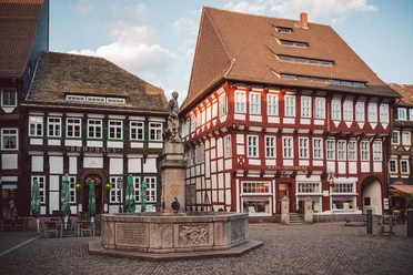 Marktplatz_mit Till Eulenspiegel, Brodhaus und Rats-Apotheke Till-Eulenspiegel-Brunnen auf Kopfsteinpflaster vor Brodhaus und roter Rats-Apotheke.