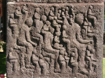 Skulptur Der Vorleser Relief einer Steinplatte mit zahlreichen stilisierten Menschenfiguren, in Leseposen vertieft.