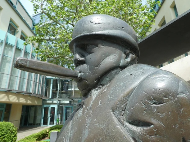 Bronzeskulptur eines Zigarrenmachers mit gezielt geformten Details im Gesicht und einer Zigarre.