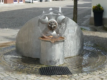 Wasserspielbrunnen "Faszination Wasser" Metallischer Wasserspielbrunnen in modernem Design mit dreidimensionaler Skulptur und fließendem Wasser.