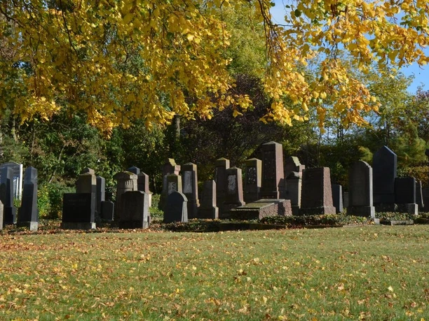 Jüdischer Friedhof in Brakel Reihen von Grabsteinen auf dem jüdischen Friedhof in Brakel, umgeben von herbstlich gefärbtem Laub.