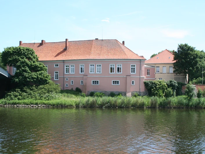 Schloß Hoya Historisches Schloß Hoya am Ufer eines Flusses, umgeben von Bäumen unter blauem Himmel.Historic Hoya Castle on the banks of a river, surrounded by trees under a blue sky.Det historiske Hoya-slot ligger ved bredden af en flod, omgivet af træer under en blå himmel.Historisch kasteel Hoya aan de oever van een rivier, omringd door bomen onder een blauwe hemel.