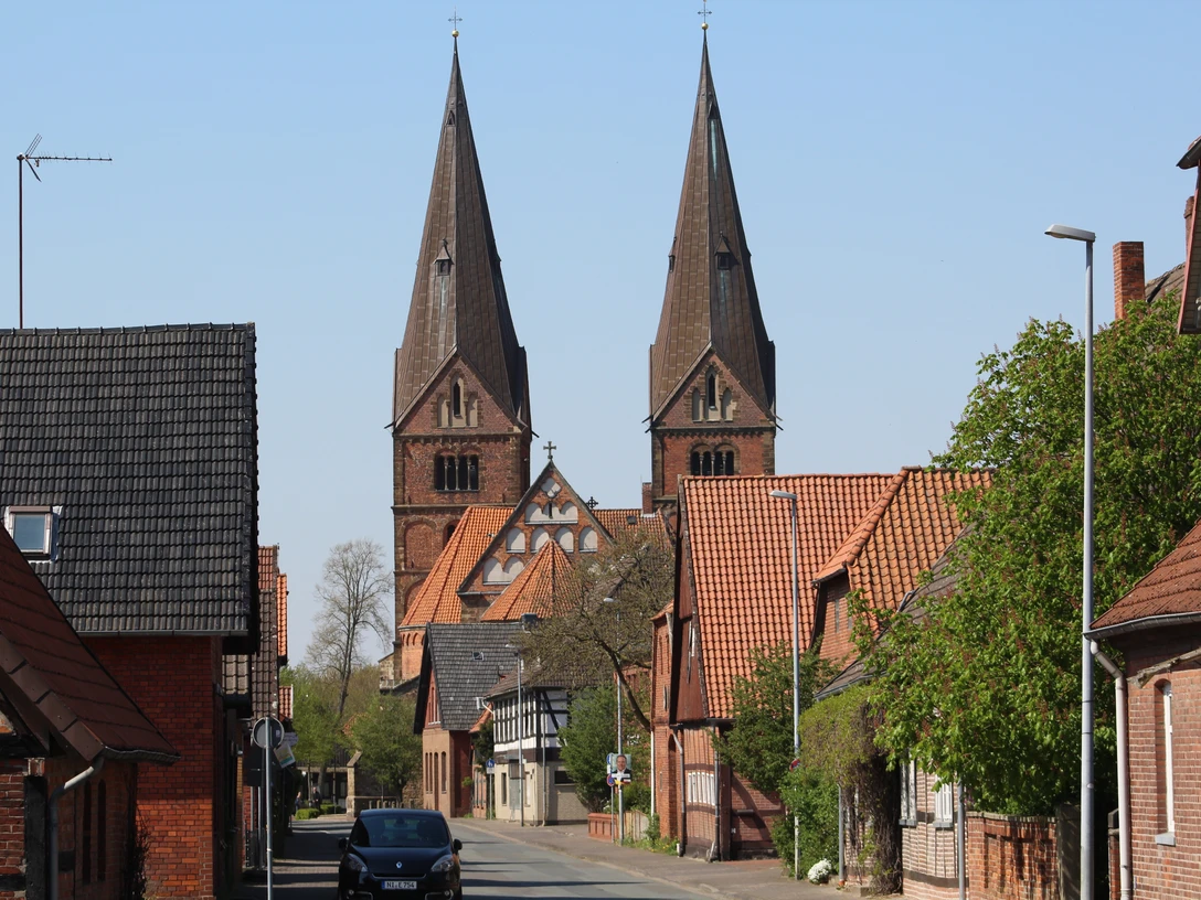 SG Grafschaft Hoya Stiftskirche Bücken Zwei beeindruckende Kirchtürme ragen in den Himmel über der schläfrigen Straße in Bücken.