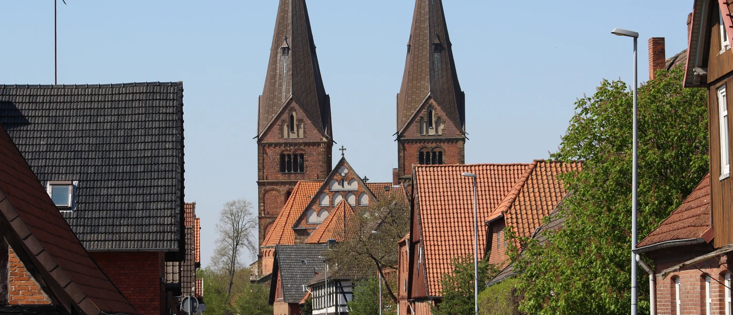 SG Grafschaft Hoya Stiftskirche Bücken Zwei beeindruckende Kirchtürme ragen in den Himmel über der schläfrigen Straße in Bücken.