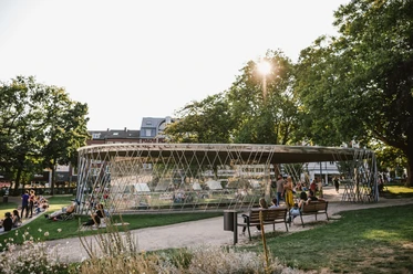 Eine modern gestaltete Glasvitrine im Park, wo Besucher*innen die archäologischen Ausstellungsstücke bewundern können.