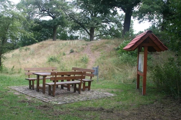 alte Schanze Rohrsen Picknicktisch mit Sitzbänken vor einem grasbewachsenen Hügel und Schautafel im Naturgebiet.