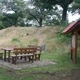 alte Schanze Rohrsen Picknicktisch mit Sitzbänken vor einem grasbewachsenen Hügel und Schautafel im Naturgebiet.