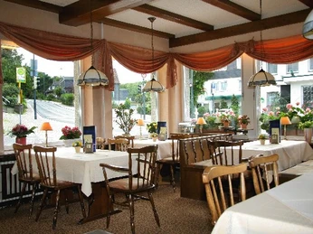 Hotel Laber Gemütlicher Speiseraum mit Holzmöbeln, weißen Tischdecken und großen Fenstern mit Ausblick.