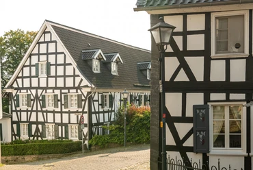 Ortskern Ruppichteroth <p>Fachwerkhäuser in sonnigem Dorf Ruppichteroth, mit grünen Akzenten und historischer Architektur.</p>