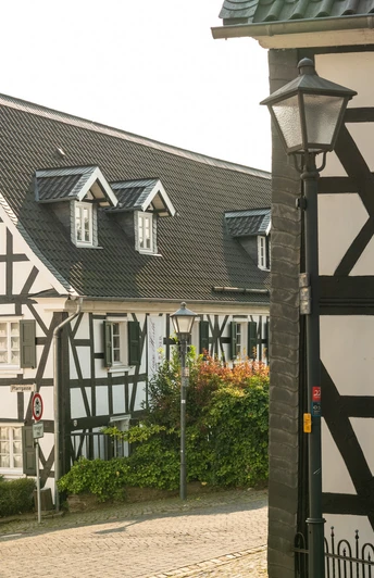 Ortskern Ruppichteroth <p>Fachwerkhäuser in sonnigem Dorf Ruppichteroth, mit grünen Akzenten und historischer Architektur.</p>