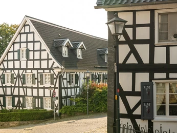 Ortskern Ruppichteroth <p>Fachwerkhäuser in sonnigem Dorf Ruppichteroth, mit grünen Akzenten und historischer Architektur.</p>