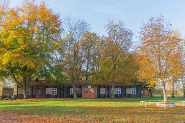 Emslandlager Versen Holzbaracke des Emslandlagers Versen im Herbst, umgeben von Bäumen mit buntem Laub