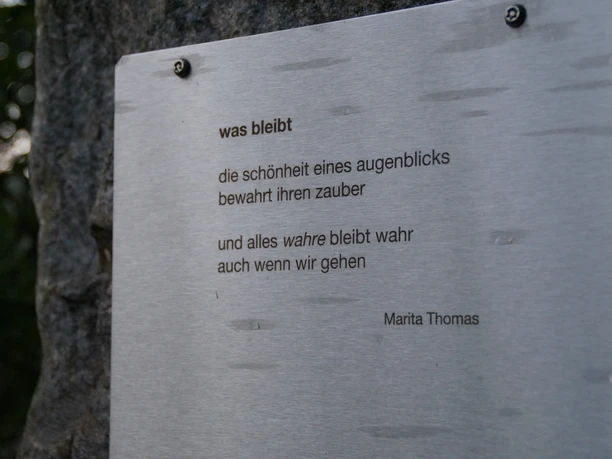 Poetische Wanderung rund um Overath <p>Silbernes Schild mit Gedicht von Marita Thomas auf einem Baumstamm montiert.</p>