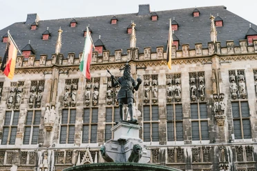 Karlsbrunnen Aachen mit Rathaus Karlsbrunnen vor dem mit Fahnen geschmückten Rathaus auf dem Markt.