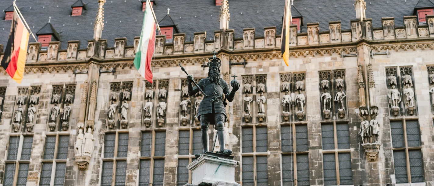 Karlsbrunnen vor dem mit Fahnen geschmückten Rathaus auf dem Markt.