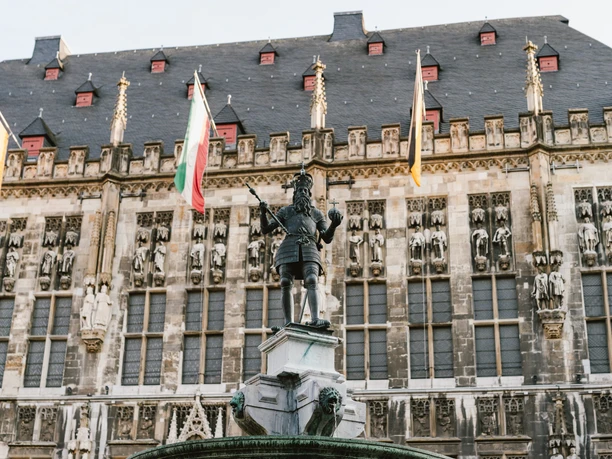 Karlsbrunnen Aachen mit Rathaus Karlsbrunnen vor dem mit Fahnen geschmückten Rathaus auf dem Markt.