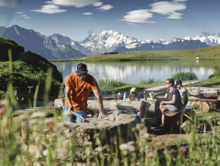 Familie am braeteln bei der Feuerstelle Bettmersee