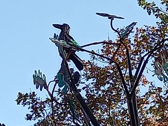 Lieblingsort Godensholt-Eiche mit Rabe Es ist eine grosse Stahlfigur in Form einer Eiche mit einem Raben aus Stahl zu sehen