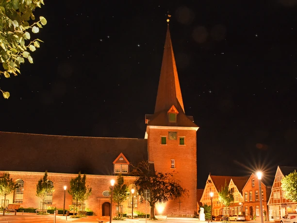 Prachtvoll beleuchtete Backsteinkirche St. Severi bei Nacht unter einem Sternenhimmel.