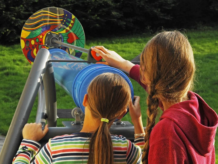 Mädchen am Drehscheibenkaleidoskop Zwei Mädchen stehen am Drehscheibenkaleidoskop.