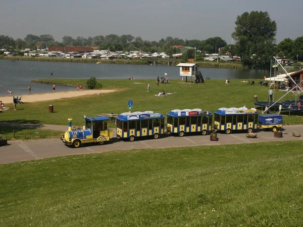 Strand-Express - Cuxliner Blaue Bimmelbahn vor See und Strand.