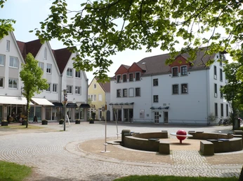 Alter Markt Historische Häuser mit Fachwerkdetails umgeben einen offenen Platz mit Bäumen, Sitzbänken und Brunnen.