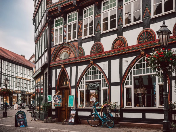 Fachwerk in der Lange Brücke Reich verziertes Fachwerkhaus Einbeck am Tag. Davor parkt ein blaues Fahrrad.