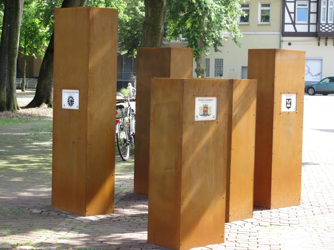 Sechs hohe, rostfarbene Stelen im Freien repräsentieren die Städtepartnerschaften von Celle.