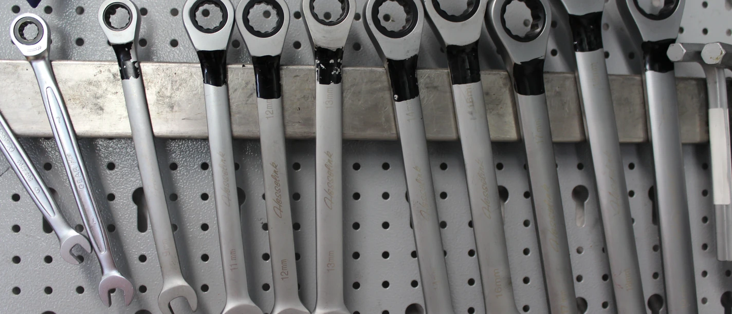 Schraubenschlüssel Verschiedene Schraubenschlüssel hängen ordentlich an einer Lochwand, bereit für den Einsatz in der Werkstatt.