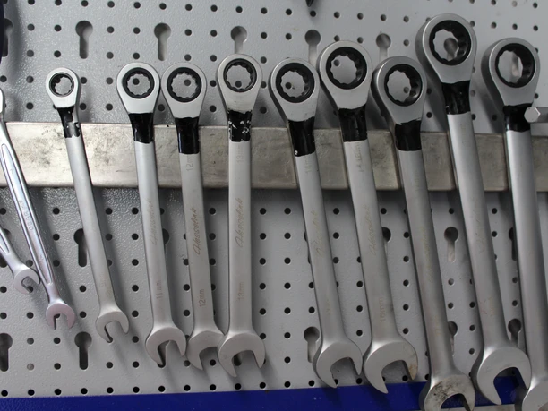Schraubenschlüssel Verschiedene Schraubenschlüssel hängen ordentlich an einer Lochwand, bereit für den Einsatz in der Werkstatt.