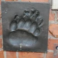 Bronze Relief Bärentatze Ein in eine Ziegelwand eingelassenes Bronzereflief zeigt den detaillierten Abdruck einer Bärentatze.A bronze relief set into a brick wall shows the detailed imprint of a bear's paw.Et bronzerelief i en murstensvæg viser det detaljerede aftryk af en bjørnepote.Een bronzen reliëf in een bakstenen muur toont de gedetailleerde afdruk van een berenpoot.