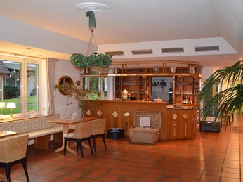 Frühstücksraum Ein einladender Frühstücksraum mit Holzmöbeln und Blick auf eine gemütliche Außenterrasse.