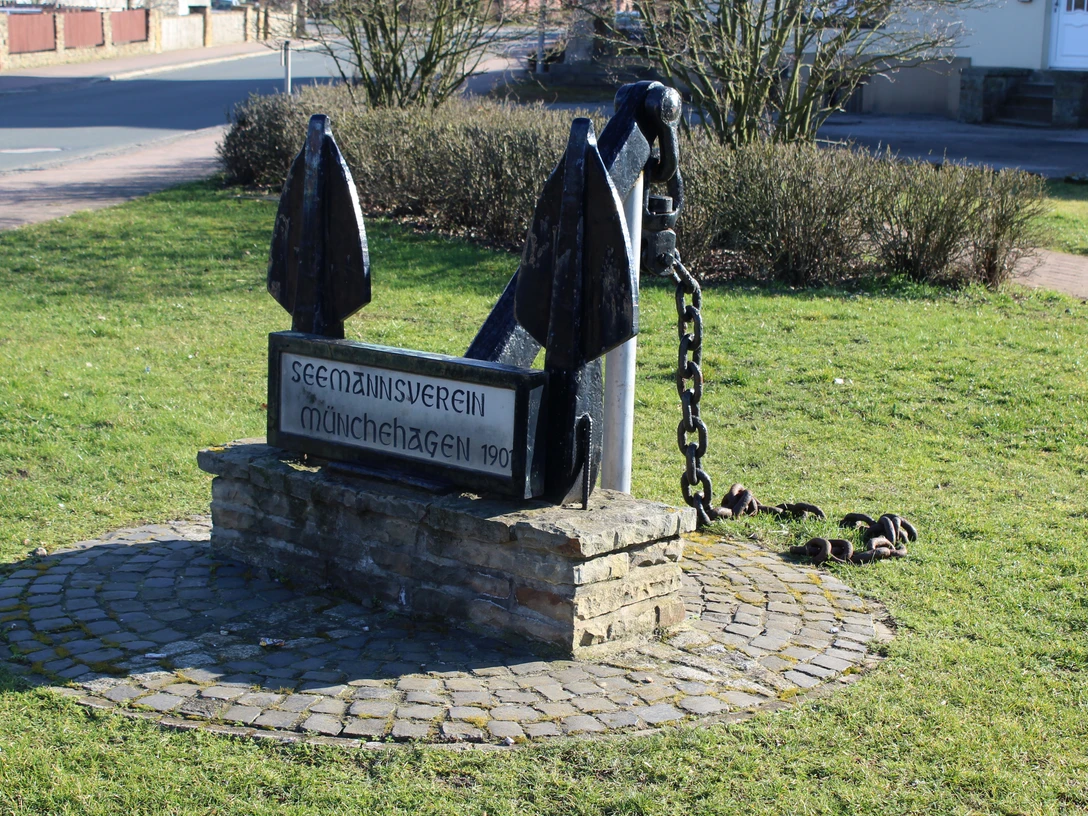 Großer, schwarzer Anker aus Metall auf einem gepflasterten Sockel, gewidmet dem Seemannsverein Münchehagen von 1901.