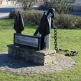 Skulptur-Anker-Münchehagen Großer, schwarzer Anker aus Metall auf einem gepflasterten Sockel, gewidmet dem Seemannsverein Münchehagen von 1901.
