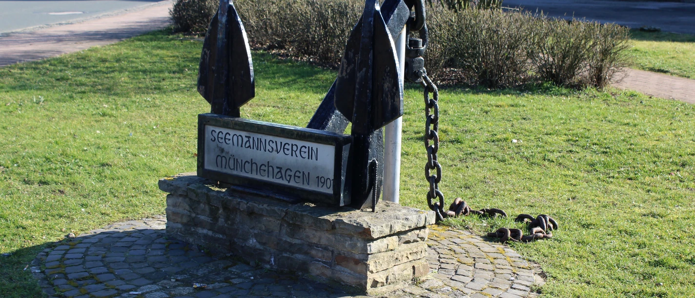 Skulptur-Anker-Münchehagen Großer, schwarzer Anker aus Metall auf einem gepflasterten Sockel, gewidmet dem Seemannsverein Münchehagen von 1901.