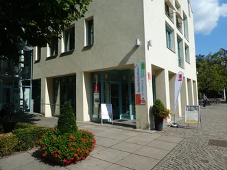 Entrance to the Achim Tourist Information Office, invitingly decorated with flower pots and information boards.