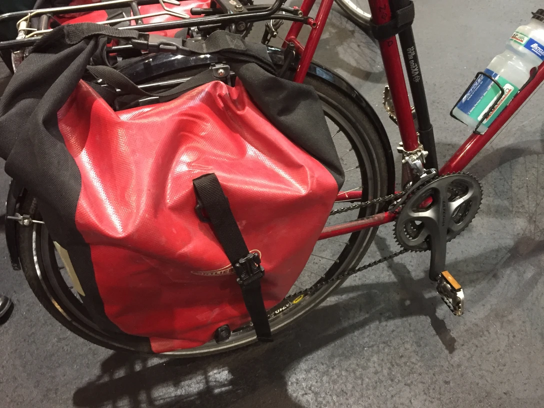 Fahrradtasche Rote Fahrradtasche aus wasserdichtem Material an einem Fahrradrahmen, geschützt vor Regen.