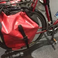 Fahrradtasche Rote Fahrradtasche aus wasserdichtem Material an einem Fahrradrahmen, geschützt vor Regen.