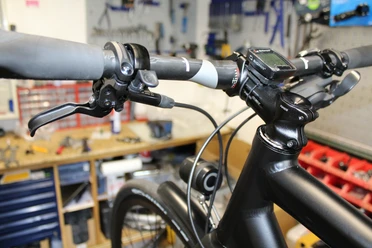 Fahrradlenker in einer Werkstatt, umgeben von Werkzeug, geeignet für Radpflege und Reparaturarbeiten.
