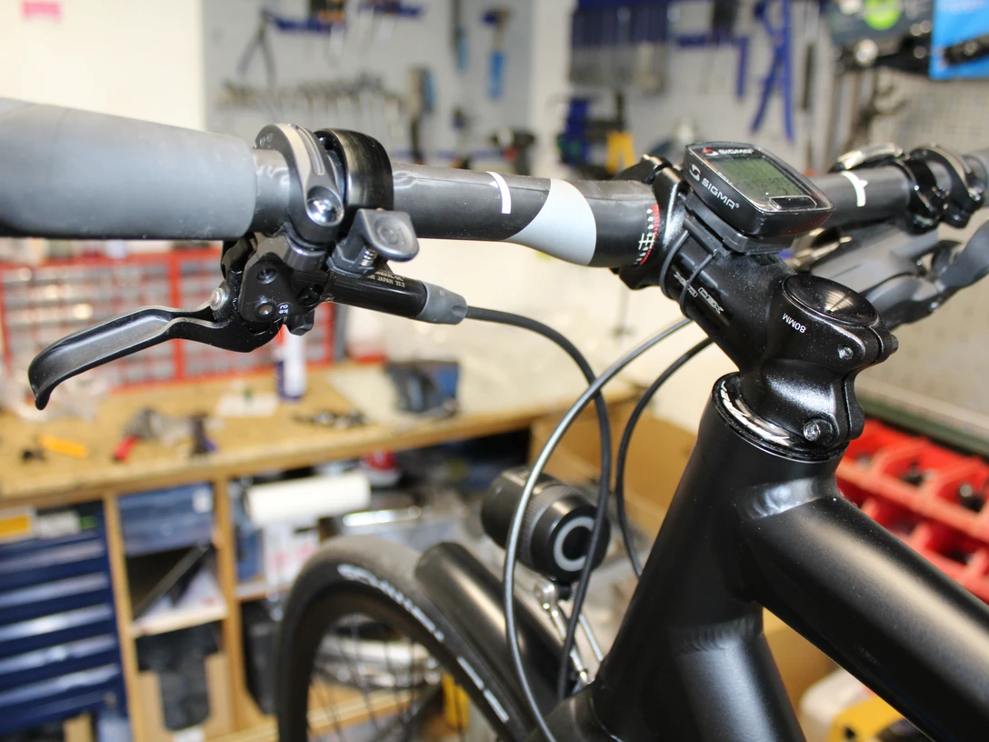 Fahrradlenker in einer Werkstatt, umgeben von Werkzeug, geeignet für Radpflege und Reparaturarbeiten.